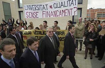 El presidente Olivas, a la izquierda, con el rector Francisco Toledo, ayer, ante las pancartas y los universitarios que le abuchearon.