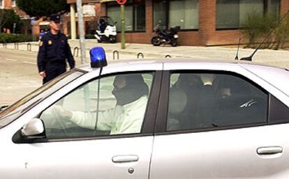 Un coche de policía en el que se cree que uno de los sospechosos detenidos ayer era trasladado a la Audiencia Nacional.
