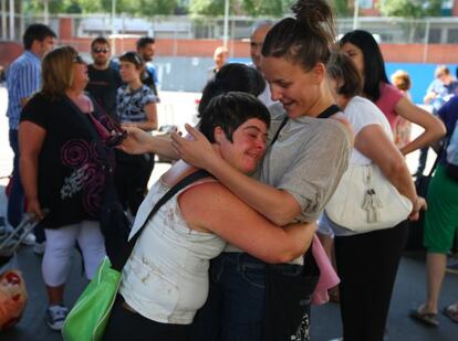 Una participante en el programa de vacaciones se abraza a una de las monitoras.
