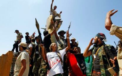 Los rebeldes disparan en el aire delante de la residencia del líder libio Muamar el Gadafi, Bab Aziziya en Trípoli