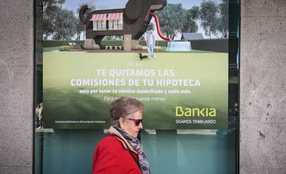 Una mujer pasa ante cartel que publicita hipotecas en una sucursal bancaria. 