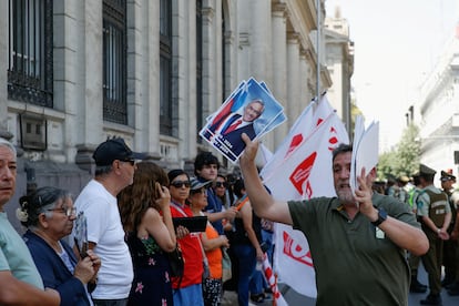 Tras su llegada al Aeropuerto de Santiago, el féretro con los restos de Piñera será trasladado hasta la antigua sede del Congreso Nacional. En la imagen, un hombre vende fotografías de Piñera a las afueras del Congreso, este miércoles.