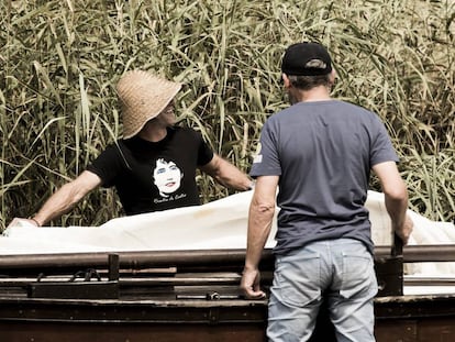 Dos participantes en la remontada del río Ulla en honor a Rosalía de Castro preparan su embarcación.