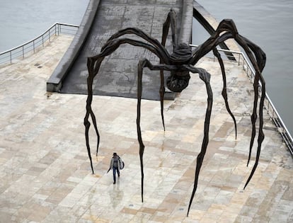 Una persona camina bajo la escultura de Louise Bourgeois 'Mamá', en las inmediaciones del Museo Guggenheim de Bilbao, el 27 de abril.