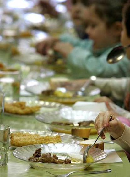 Una niña aparta la carne del primer plato que le han servido en el comedor del colegio.