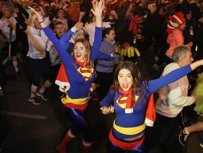 Dos corredoras disfrazadas de Superman participan en la San Silvestre de Valencia 2014.