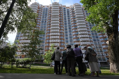 People look at a the apartment building in Moscow, Russia