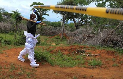 A homicide detective crosses the cordon line to exhume bodies of suspected members of a Christian cult named as Good News International Church