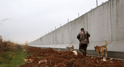 Un combatiente kurdo camina la semana pasada cerca del muro de la frontera turco-siria.