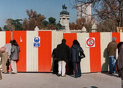 Varios paseantes del Retiro miraban ayer a través de las vallas que rodean el estanque vacío del parque madrileño.