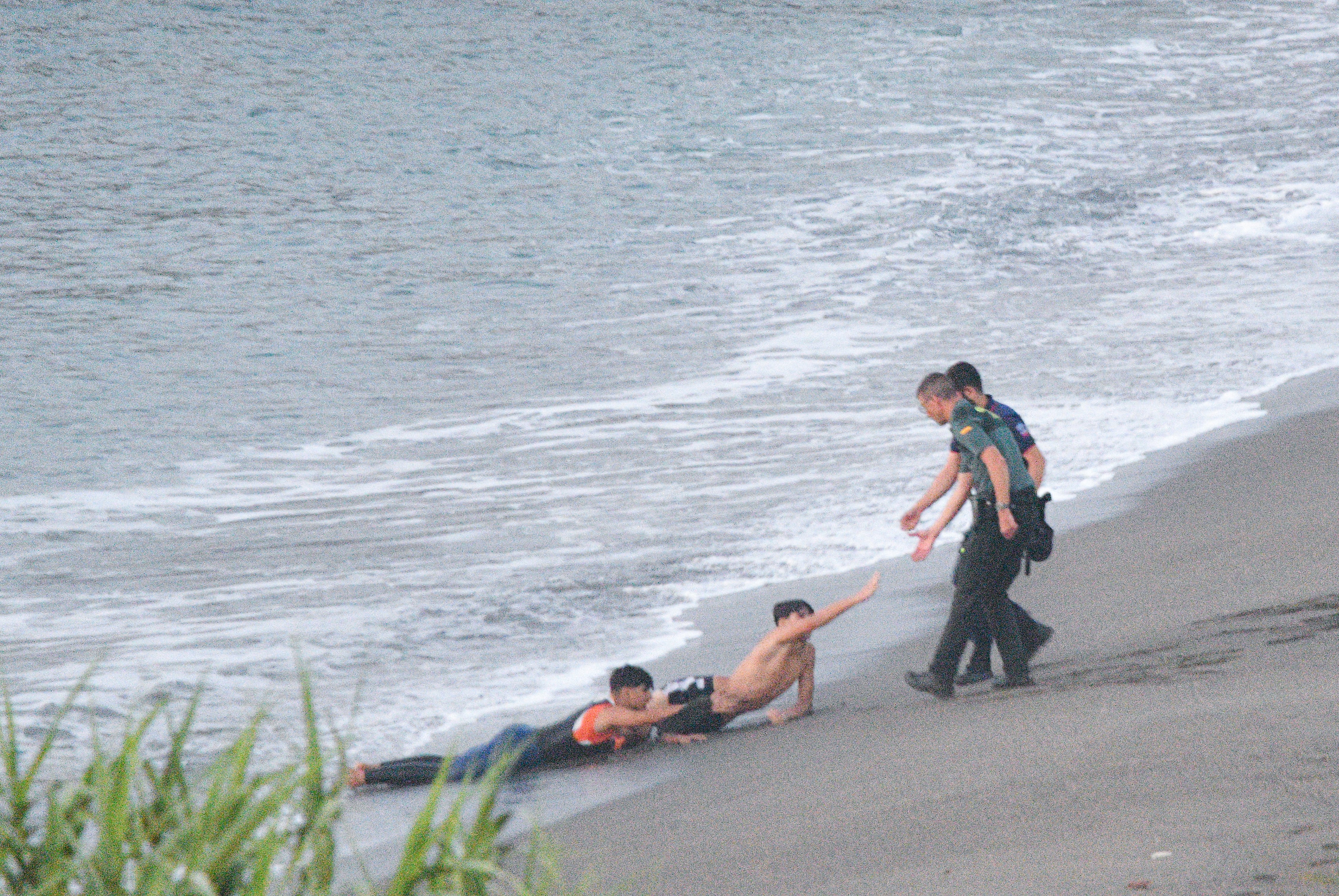 Dos jóvenes migrantes en una playa de Ceuta piden ayuda a la Guardia Civil.