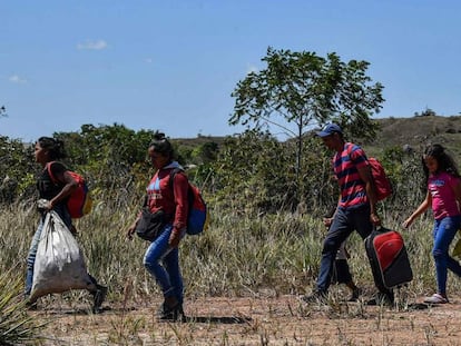 Venezuelanos caminham em Pacaraima, Brasil, depois de cruzar a fronteira.
