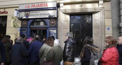 Un grupo de personas espera para comprar su d&eacute;cimo de loter&iacute;a en Madrid.