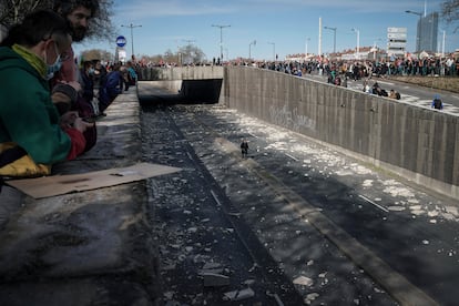 Una mujer camina por una carretera cortada al tráfico por los manifestantes, en Lyon.
