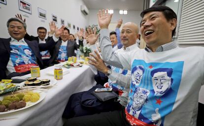 Un grupo de surcoreanos residentes en Singapur siguen un programa de televisión que se hace eco de la histórica cumbre entre el presidente estadounidense, Donald J. Trumo, y el líder norcoreano, Kim Jong-un.