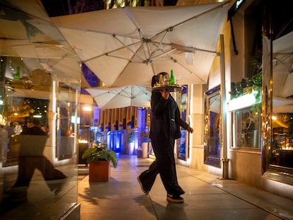 Una camarera trabajando de madrugada en un céntrico restaurante de Madrid.