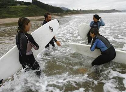 Surfistas en el Arenal de Morís, una playa de 770 metros de longitud en Caravia (Asturias).