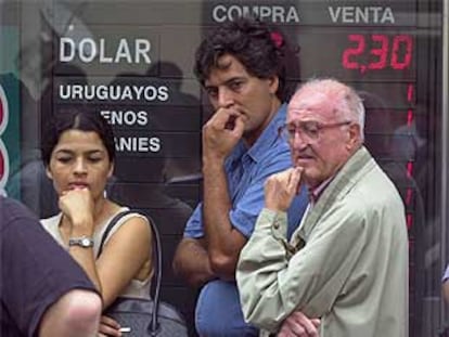 Un grupo de argentinos hacen cola en una casa de cambio para comprar dólares.