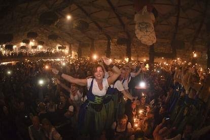 Una camarera enciende bengalas junto al resto de asistentes al Oktoberfest durante el cierre de la edición de este año, en Múnich.