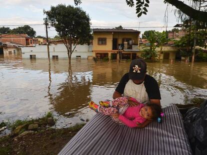 Un hombre juega con su hija en mitad de la inundación en Cali, Colombia.