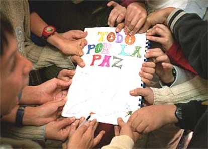 Alumnos del Colegio Montserrat de Madrid muestran un mensaje en el que piden la paz.