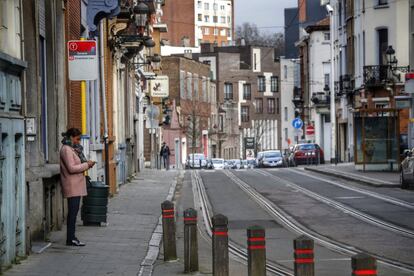 Una mujer aguarda el paso del tranvía en el barrio de Schaerbeek, el miércoles. La policía ya ha dejado la zona después de la operación policial que efectuó el martes en el piso de los terroristas que atentaron en el aeropuerto, donde encontraron un arsenal.