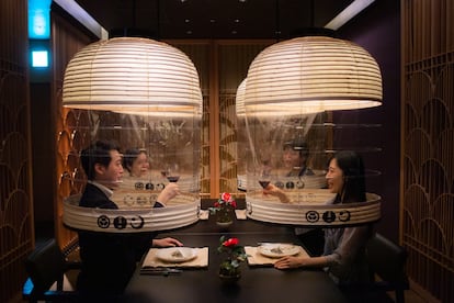 Empleados del hotel Hoshinoya de Tokio, en una demostración del sistema Lantern Dining Experience, para proteger a clientes sin usar mascarilla anticovid.