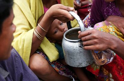 Un niño refugiado rohingya bebe agua del río mientras él y sus familiares esperan ser llevados a un campamento de refugiados después de cruzar el río Naf, en la frontera entre Bangladés y Myanmar en Palang Khali.