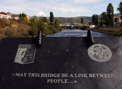 Placa con una grabación en la que se puede leer "que este puente sea un lazo entre personas", situada al pie de un puente contruido por las tropas de las Naciones Unidas encargadas de mantener la paz en la ciudad de Mitrovica, Kosovo