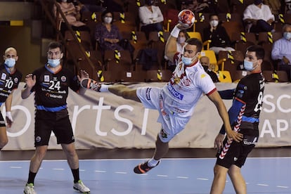 El jugador del Ademar Drew Donlin (centro) lanza ante los jugadores del Sinfín en el partido de la octava jornada de la Liga Asobal disputado este sábado en el Palacio Municipal de Deportes de León.