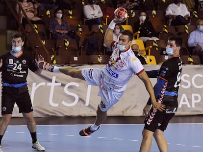 Donlin, del Ademar León, lanza entre dos jugadores del Sinfín, en el partido del 10 de octubre.