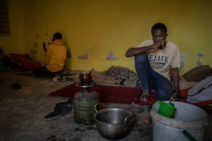Boubacar Sakho prepará el té, mientras Bacar Sumaré reza en el fondo de la habitación que comparten junto a otros compañeros malienses. Justo a su izquierda en un colchón maltrecho descansa otro de los compañeros que ha caido enfermo con malaria. En Nuadibú, Mauritania. 