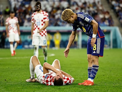 Borna Barisic, de Croacia, tendido en el suelo mientras el japonés Ritsu Doan le presta su ayuda. 