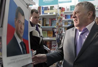 El candidato presidencial y líder del Partido Liberal Democrático de Rusia, observa una fotografía del presidente ruso, Dimitri Medvedev, durante su visita a una libreria en Moscú (Rusia).