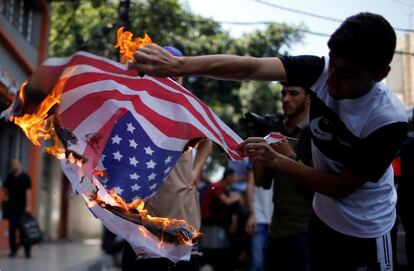 Un manifestante palestino quema una bandera estadounidense durante una protesta en Ciudad de Gaza.