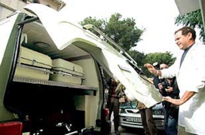 Un empleado de la funeraria cargaba ayer los féretros de la mujer y los tres hijos en un furgón en Tuéjar.