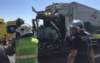 Unos bomberos, delante del cami&oacute;n siniestrado en la AP-6.