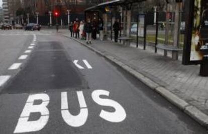 Varias personas esperan el autobús en una parada del Paseo de la Castellana de la capital. EFE/Archivo