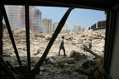 Varios libaneses buscan sus pertenencias entre los escombros en sus casas del barrio beirutí de Dahiyeh, bombardeado por Israel, el 23 de julio de 2006.