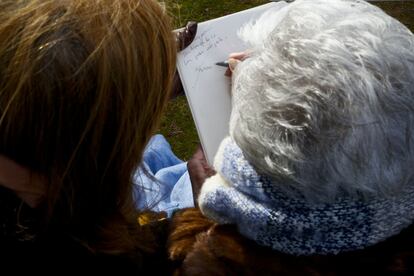 Ascensión, acompañada por su hija Pilar, firma en en libro de visitas de la Asociación para la Recuperación de la Memoria Histórica.