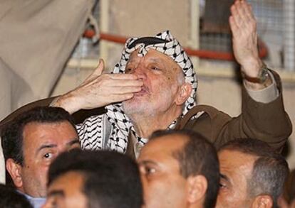 Arafat saluda a sus seguidores, concentrados alrededor de su cuartel general en Ramala.