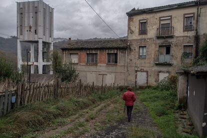 La región carbonífera de Asturias tiene una tasa de desempleo del 26%, con un 31% de más de 65 años. Su economía se basa en subsidios de jubilación anticipada y pensiones de jubilación, y no tiene ningún plan de la nueva industria para llevar el relevo al carbón. En la imagen, una mujer camina entre edificios que pertenecen a la mina Pozo Candín, que cerró en 2012, en Langreo (Asturias).
