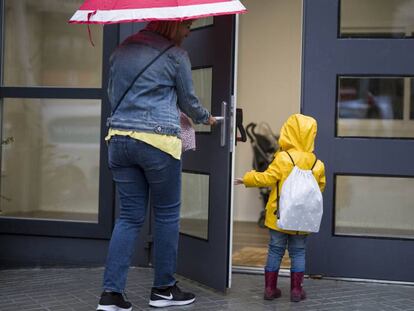 Una madre lleva a su hija a un colegio