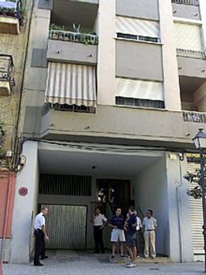 La Policía y vecinos ante la puerta del edificio de Benimacle en el que un hombre apuñaló a sus dos hijos.
