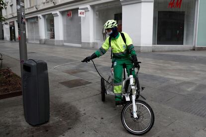 Un trabajador del servicio de limpieza del Ayuntamiento de Madrid desinfecta una papelera.
