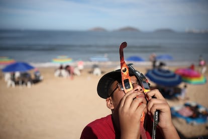 Un niño usa dos juegos de anteojos para ver el eclipse en Mazatlán.