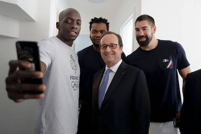 O presidente da França, François Hollande (ao centro), posa para uma selfie com membros da equipe francesa de handball, Olivier Nyokas (à esquerda), Cedric Sorhaindo (segundo à esquerda) e Nikola Karabatic (à direita), em visita à Vila Olímpica nesta quinta.