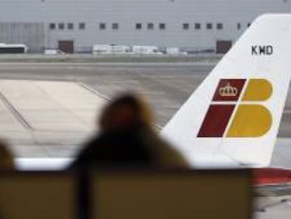 Dos personas ante un avión de Iberia, en el aeropuerto Adolfo Suárez - Barajas. EFE/Archivo
