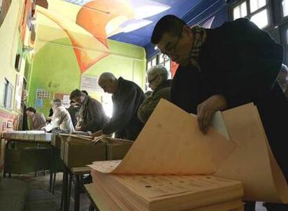 Un ciudadano coge papeletas del Senado en el colegio Pi y Margall.