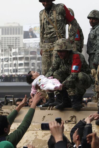 Un soldado subido a un tanque sostiene a un bebé durante una manifestación en El Cairo.